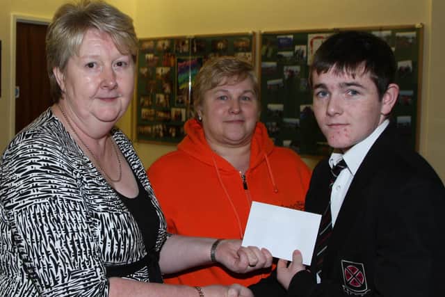 Anna Benton and Valerie Getty of the Cullybackey High School Parents’ Association present a cheque to pupil Sam Wilson who has won the Ulster and Irish motocross championships. BT49-115JC