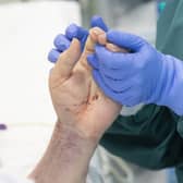 A nurse holds the hand of a patient