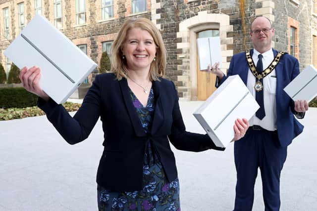 Mayor of Antrim and Newtownabbey, Councillor Jim Montgomery presents Dr Catherine Scully, Principal of Jordanstown School with a number of iPads aimed at addressing digital poverty in local communities.