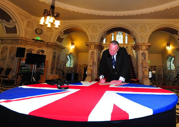 An actor playing Edward Carson re-enacts the signing of the 1912 Ulster Covenant at Belfast City Hall in 2012