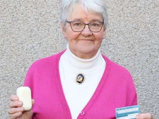 Christian Aid supporter Nora Gibson with a bar of soap and her vaccine card.