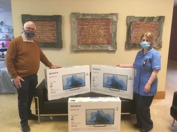 Chairman David Savage of ''Friends and Relatives of Thompson House'' is seen here presenting the TVs to staff nurse Fiona Connolly much to the delight of the patients