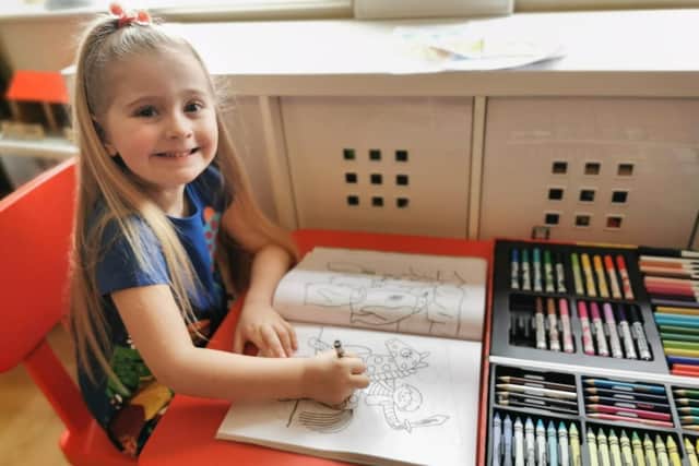 Poppy Ashton with her colouring book and pencils