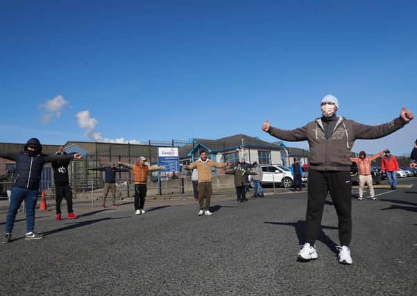 Press Eye - Belfast - Northern Ireland - 27th March 2020 - 

General views of meat factory workers outside the Linden Foods factory in Dungannon. The employees walked out complaining that there were not adequate social distancing measures in place. 

Photo by Kelvin Boyes / Press Eye.