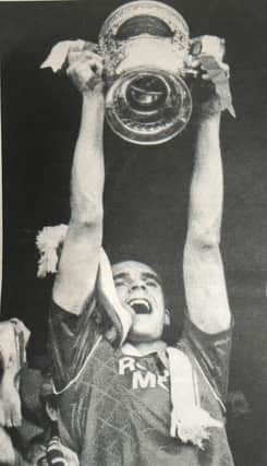 Portadown captain Brian Strain lifts the Gibson Cup in 1990 at Shamrock Park.