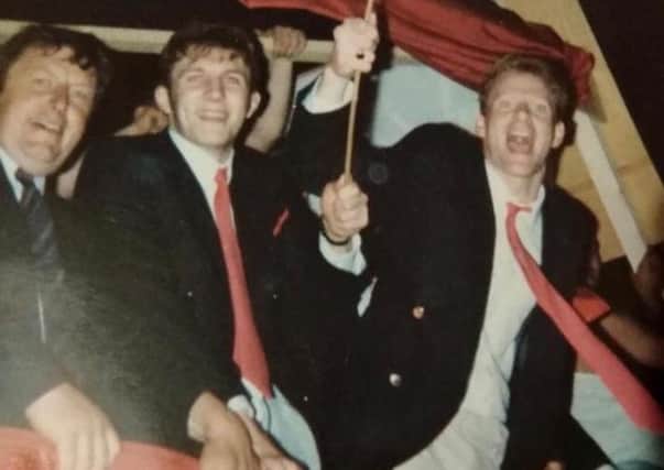 Neil McCullough during the trophy parade to celebrate Portadown's first-ever Irish League title triumph in 1990. Also included are, from left, his father, Barry (the reserve-team manager) and team-mate Davy Mills.