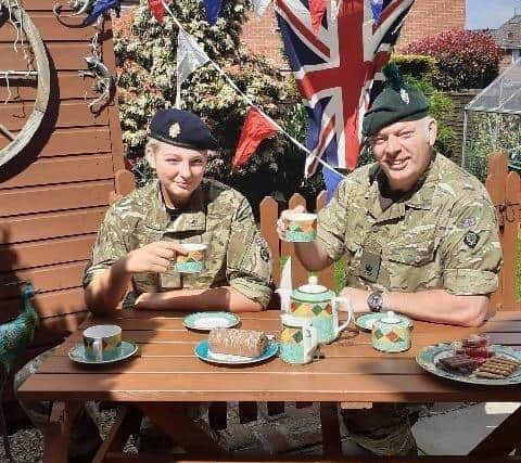 Major John Read of C Company ACF enjoys tea and cake with his daughter at their VE Day garden party.