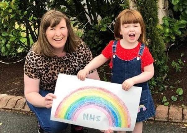 Councillor Lauren Gray pictured with her daughter, Maisie, and her fantastic rainbow for NHS and keyworkers.