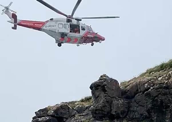 The coastguard helicopter lifted one youth from the water to the clifftop. Photo: McAuley Multimedia