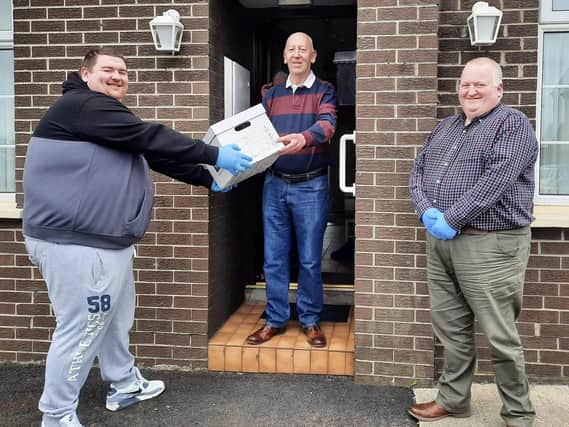 Alan McClenaghan and Councillor Wesley Brown deliver a care package to Jim Ballentine from Leckagh Neighbourhood Partnership.