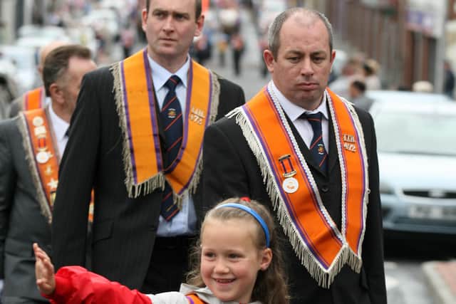 Giving a wave to her friends as this young girl marches at the Twelfth celebrations in Ballymena. BT29-249AC