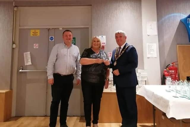 Karen Phillips receiving her award from Mayor of Antrim and Newtownabbey, Cllr Billy Webb, alongside Cllr Robert Foster.