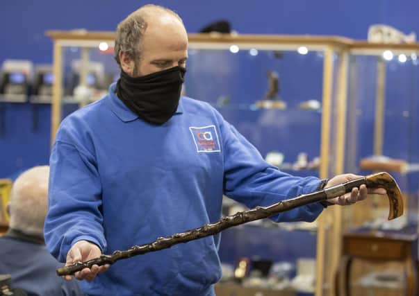A member of the Bloomfield Auctions team in east Belfast, holds a walking stick once owned by Northern Ireland's first Prime Minister, James Craig, 1st Viscount Craigavon, which sold for £10,000 to an online bidder. It was estimated that the blackthorn cane would sell for between £4,000 and £6,000.