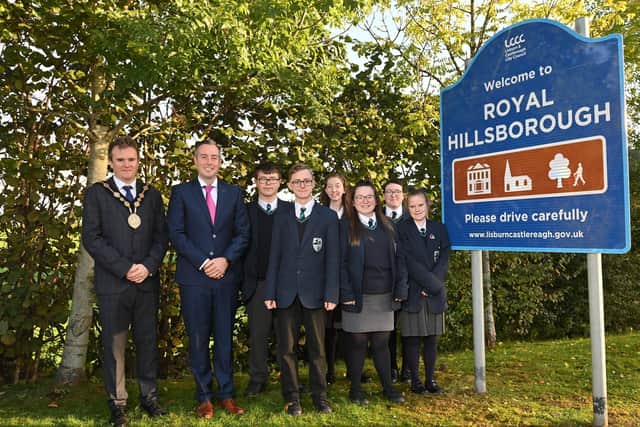 Mayor of Lisburn & Castlereagh City Council, Alderman Stephen Martin and First Minister Paul Givan MLA are joined by pupils from Beechlawn School at the unveiling of the new Royal Hillsborough signage.