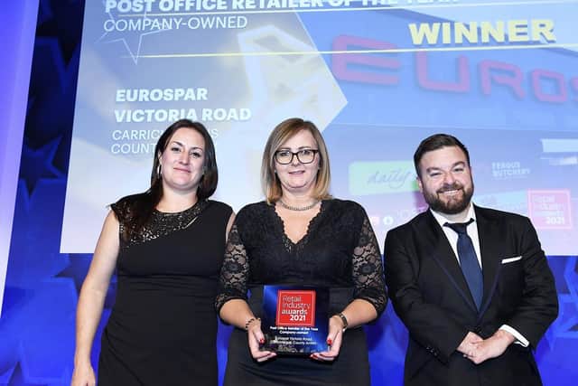 Laura McClean (centre) from Henderson Group picks up the Post Office Retailer of the Year Award for Eurospar Victoria Road at the Retail Industry Awards in London. Also pictured is Kim Reddick, commercial director at the Retail Industry Awards and host Alex Brooker.