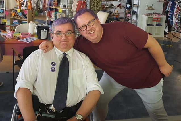 Ken Wright, pictured just days before he got Covid, in the Ballymena charity shop which he runs. Both Ken (right) and volunteer Phillip dyed their hair purple for Austim Awareness and World Mental Health