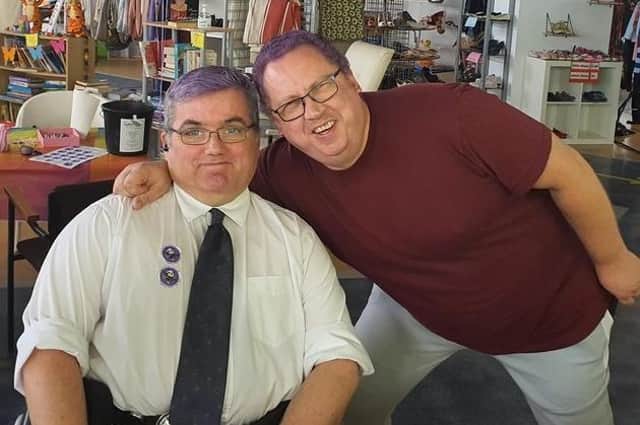Ken Wright, pictured just days before he got Covid, in the Ballymena charity shop which he runs. Both Ken (right) and volunteer Phillip dyed their hair purple for Austim Awareness and World Mental Health