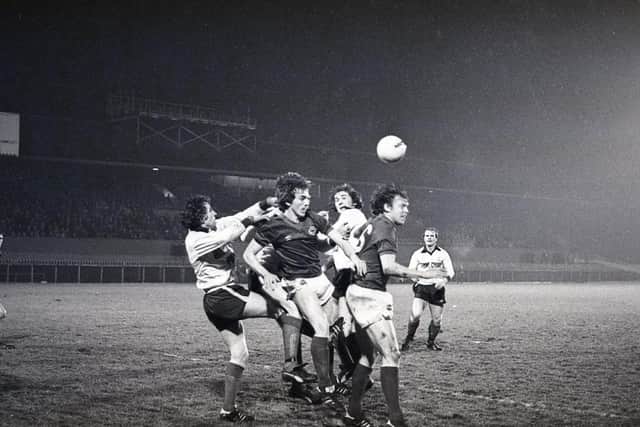 Lisburn Distillery's goalkeeper Terry Nicholson punches the ball away during a concentrated Linfield attack by Martin McGaughey and Peter Dornan, following a corner kick at Windsor Park in January 1982. Picture: News Letter archives