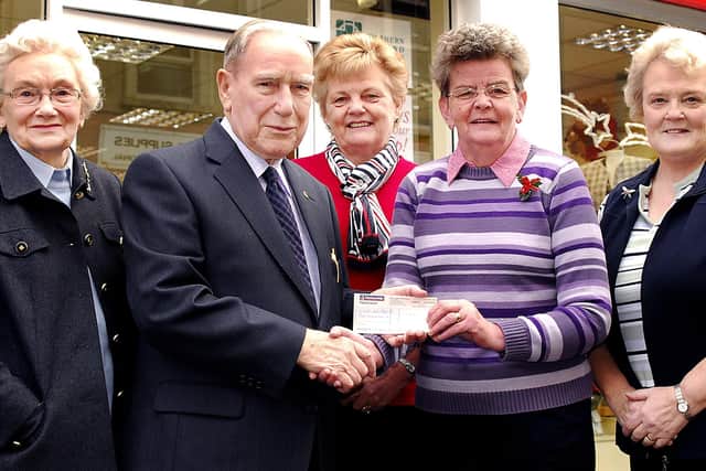 Marlene Kyle, Hospice Shop Manager, receives an £800 cheque from John Luke, author of the "Harryville Joke Book" watched by Margaret McCloy, Martha Francey and Maureen Meneely. BT52- 812H