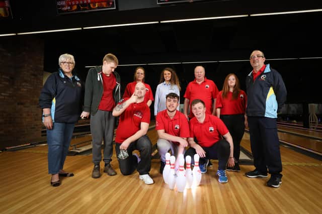 Chair Lorraine Foster (L), Bowling Head Coach David Hilland (R) and Aoife Magennis from Power NI (middle) alongside athletes and volunteers from Lisburn2gether Special Olympics Club at Lisburn Bowl. A Brighter Communities funding grant from Power NI is enabling the club to purchase additional equipment for athletes.
