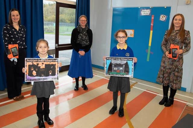 Pictured are Rasharkin Primary School pupils Maja Zip and Grace Fenton who both won computer tablets in the Housing Executive Dream Home Design competition. Also pictured (L-R) is Breena Hasson (Triangle Housing), school principal Mrs Howe and Lynsey O’Neill (Housing Executive patch
manager).