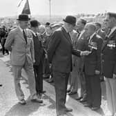 Lord Grey admires a Dunkirk medal worn by Mr Cecil McAlister from Portrush during the official opening ceremony of the new Bennet House in Portrush in September 1981. Mr Alister served in France, Italy, North Africa, Egypt, Syria and Palestine. Vice Admiral Sir Arthur Hezlet, area president of the Royal British Legion is included on the left of the photograph. Picture: News Letter archives