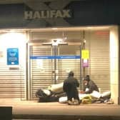A homeless man makes his bed in the doorway of the Halifax in High Street, Portadown. He is chatting to another man who had created a shelter in a doorway across the road.