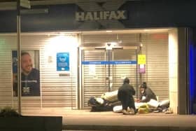 A homeless man makes his bed in the doorway of the Halifax in High Street, Portadown. He is chatting to another man who had created a shelter in a doorway across the road.