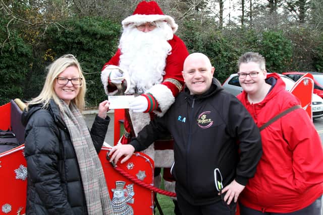 Kilroot Playgroup leader Lynn Mahood receiving a cheque for £960.00 from Robert Adams, Lindsay Nelson and Father Christmas.
