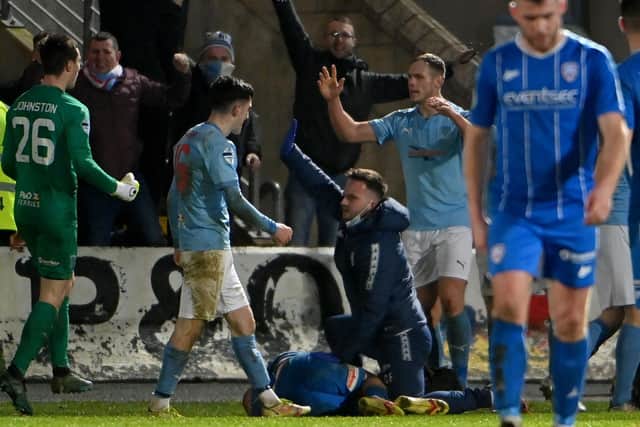 Coleraine player Conor McKendry receives treatment as Ballymena United celebrate their late winner