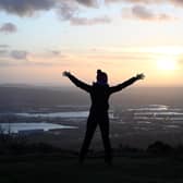 Celebrating the arrival of 2022 from the top of Cave Hill as the sun rises over Belfast on New Year's morning. Picture: Michael Cooper