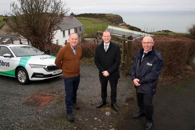Economy Minister Gordon Lyons is pictured with Michael Carson, homeowner from Islandmagee who will benefit from the extension and Conor Harrison from Fibrus Networks Ltd.