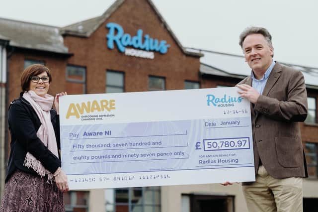 Radius Housing Chief Executive John McLean presents the cheque to AWARE NI Chief Executive Karen Collins