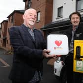 Stanley Spray, one of the first homeowners at The Tides and Jim Burke, director of sales and acquisitions, Hagan Homes, with the defibrillator at the Carrickfergus development.