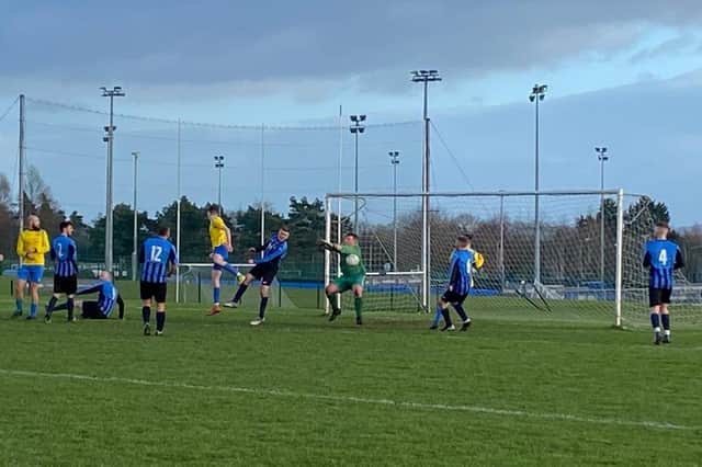 Euan Neeson rises high snd goes close for Carryduff Colts seconds against UUJ