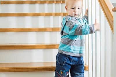 A child navigates the stairs by themselves.