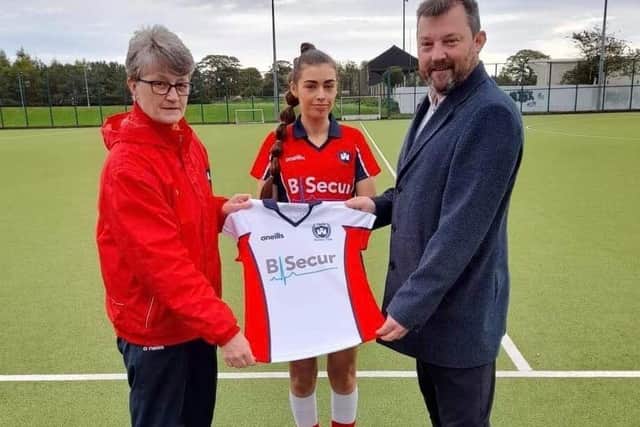 Chairperson Alyson Douglas and Castle's 1st XI captain Lyndsey McClurg accepting a new sponsored away shirt from David Brown, the Head of Operations at sponsor, B-Secur.