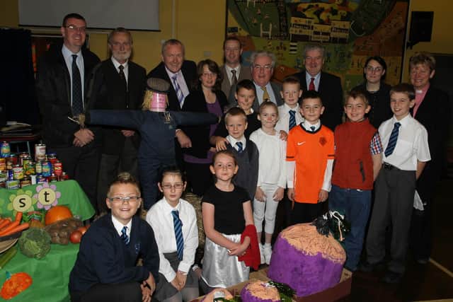 Dunclug Primary School pupils who performed in a sketch at the school's Harvest Assembly are seen here with special guests and members of the school's Board of Governors. Included are Rev Hassard, Chairman of the Board of Governors Sinclair Beattie, Ald. PJ McAvoy, Colm Best of the Dunclug Partnership and school principal Mr Reid. BT43-103JC