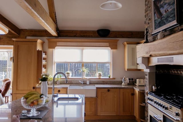 The beautifully-designed kitchen has an island unit, plenty of high and low units and a Belfast sink.