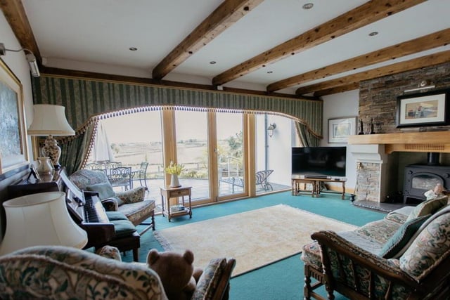 The spacious sitting room has doors opening to a patio with countryside views.