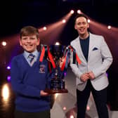 Tom Johnston from Macosquin Primary School with presenter Connor Phillips after Tom received his trophy for winning the Primary final of the BBC Northern Ireland School Soloist Of The Year 2022