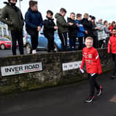 Ben sets off with the Larne FC senior squad, cheered on by local primary school children along the route. Photos: Stephen Hamilton