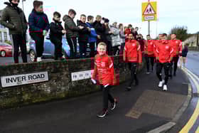 Ben sets off with the Larne FC senior squad, cheered on by local primary school children along the route. Photos: Stephen Hamilton