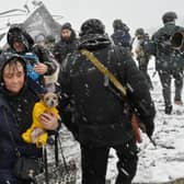 TOPSHOT - A woman carries her dog during the evacuation by civilians of the city of Irpin, northwest of Kyiv, on March 8, 2022. - More than two million people have fled Ukraine since Russia launched its full-scale invasion less than two weeks ago, the United Nations said on March 8, 2022. (Photo by Sergei SUPINSKY / AFP) (Photo by SERGEI SUPINSKY/AFP via Getty Images)