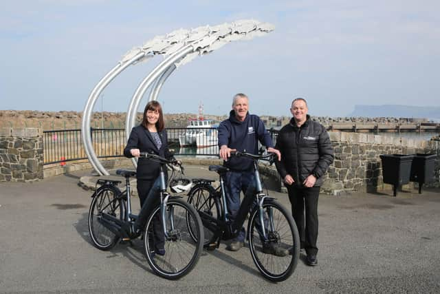 Infrastructure Minister Nichola Mallon delivers the first of 20 E-bikes to Michael Cecil, Chair of the Rathlin Development and Community Association. Also pictured is Philip McCallen who is supplying the E-bikes which will be made available for use by locals and those working on the island