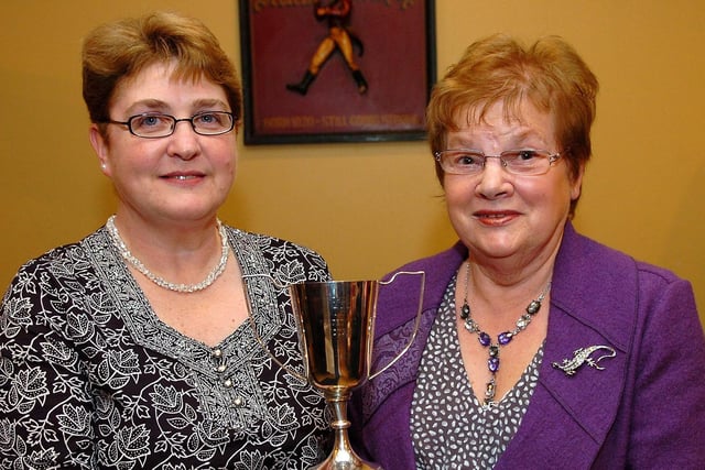 Dorothy Gray accepts the pair’s cup on behalf of herself and Tillie Dardis from Mrs Janet Porteus.