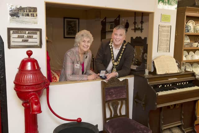 The Mayor of Causeway Coast and Glens Borough Council Councillor Richard Holmes presents one of Council’s Centenary Coin to Mrs Jennifer Gardiner on behalf of Garvagh Museum