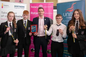 The winning Cullybackey High School team team oAmy Gibson, Christopher Michael, Rhys Wilson and Anna Aitcheson receive their award from Ballymena Rotary Club President James McClure.