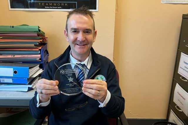 Seaview IPS principal Barry Corr with the award from Families First NI.