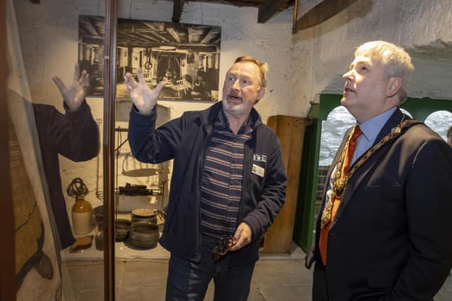 Brian Molloy, a volunteer with Friends of Ballycastle Museum, shows the Mayor of Causeway Coast and Glens Borough Council Councillor Richard Holmes some of the exhibits on display in Ballycastle Museum
